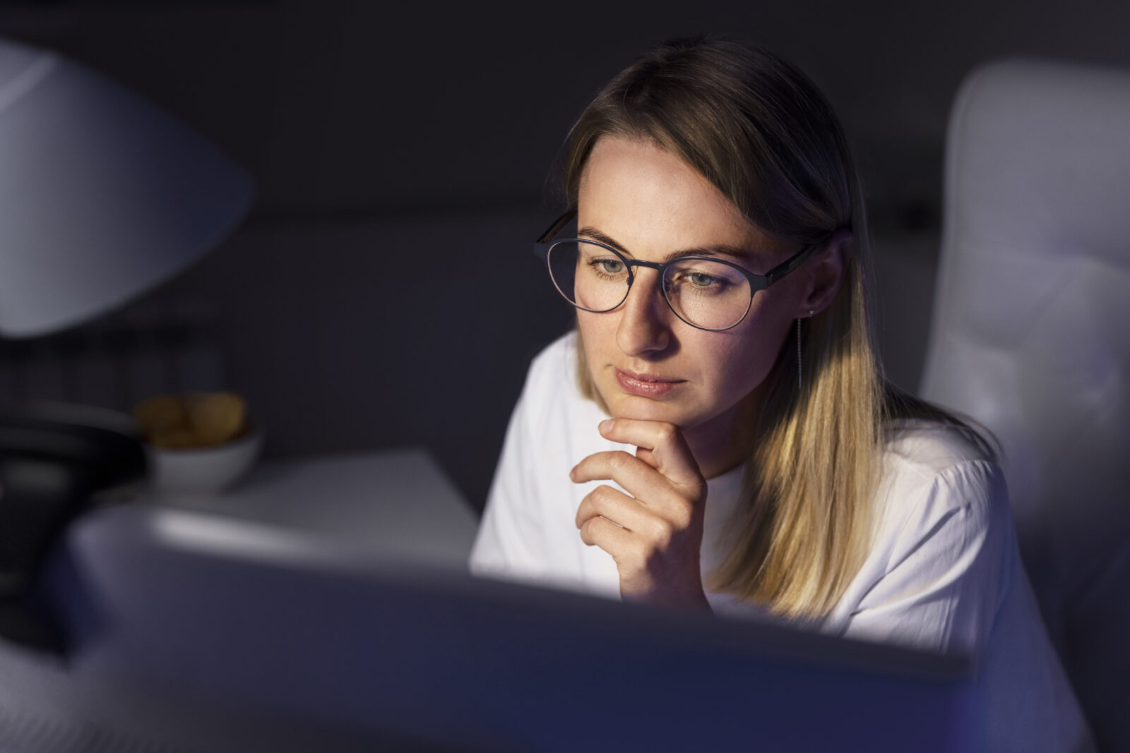 Woman in blue light glasses looking at computer